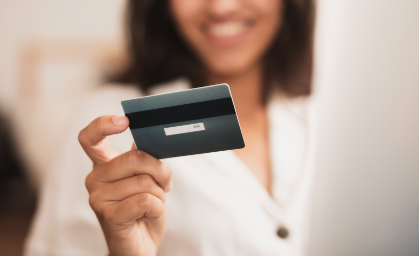 Mulher segurando cartão de crédito nas mãos