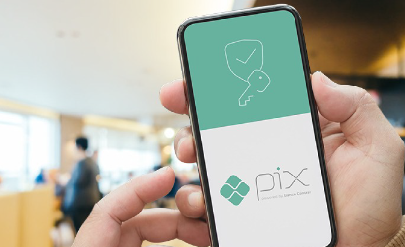 Celular nas maos mostrando o logo do pix