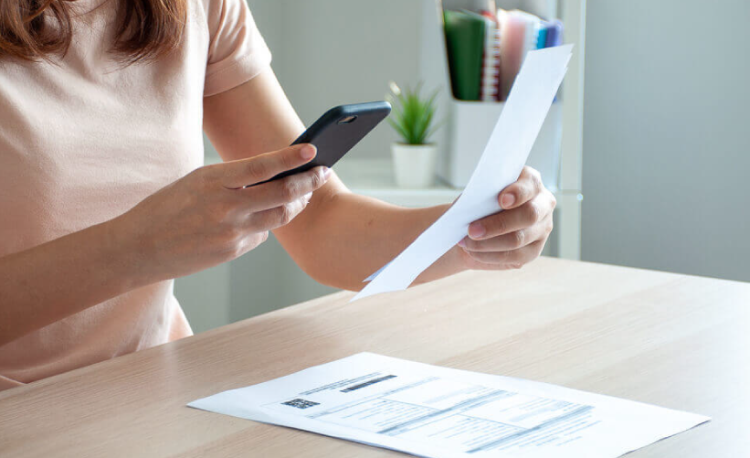 Mulher pagando um boleto com o celular